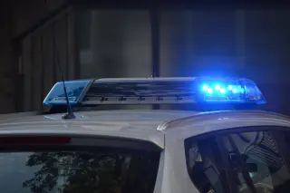 Ilustrasi: Lampu sirine biru menyala di atas atap mobil polisi.