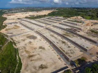 Ilustrasi: Pemandangan udara proyek pembukaan lahan dan konstruksi luas di dekat tebing pesisir.