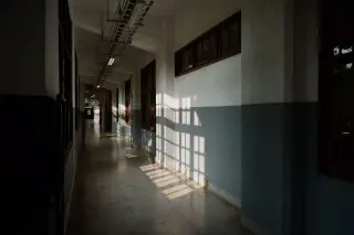 Ilustrasi: Lorong gedung kosong dengan bayangan jendela di dinding dan lantai.