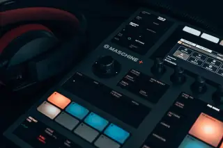Ilustrasi: Alat pengendali musik digital dan headphone di atas meja bersuasana temaram.