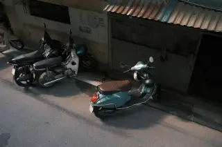 Ilustrasi: Beberapa sepeda motor terparkir di pinggir jalan dekat dinding bangunan.