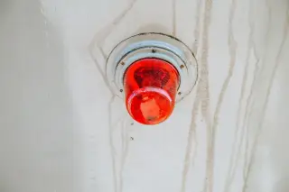 Ilustrasi: Lampu peringatan darurat berwarna merah terpasang pada permukaan logam.