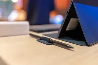 Ilustrasi: Sebuah tablet dengan penyangga dan pena digital di atas meja kayu.