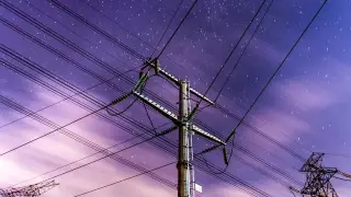 Ilustrasi: Tiang dan kabel transmisi listrik dengan latar belakang langit malam berbintang ungu.