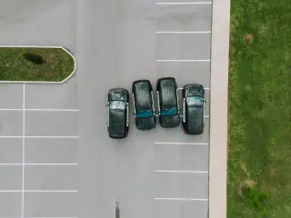 Ilustrasi: Pemandangan dari atas deretan mobil polisi terparkir di area parkir bergaris putih.