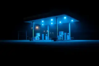 Ilustrasi: Stasiun pengisian bahan bakar yang sepi di malam hari dengan pencahayaan bernuansa biru.