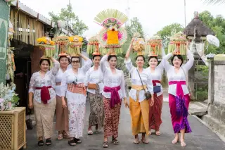 Ilustrasi: Sekelompok wanita Bali mengenakan kebaya putih berjalan sambil mengusung gebogan di atas kepala.