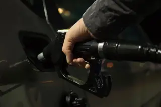 Ilustrasi: Tangan seseorang memegang nozel bahan bakar saat mengisi bensin ke tangki mobil.