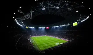 Ilustrasi: Pemandangan dari atas stadion sepak bola megah yang menyala di malam hari saat pertandingan berlangsung.