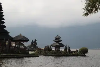 Ilustrasi: Pura Ulun Danu Beratan di tepi danau dengan latar bukit berkabut.