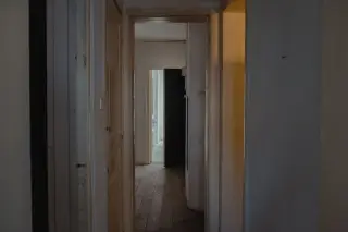 Ilustrasi: Lorong kosong di dalam bangunan tua dengan pintu terbuka di ujungnya.