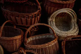 Ilustrasi: Deretan keranjang anyaman rotan dan kayu buatan tangan dengan berbagai bentuk serta warna.