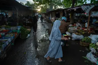 Ilustrasi: Suasana pagi di pasar tradisional dengan pedagang dan pembeli di jalan yang becek.